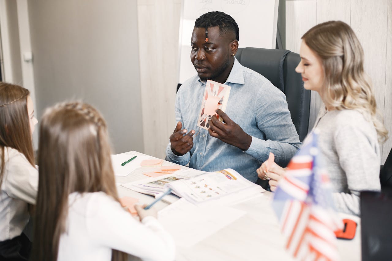 Teacher guiding diverse students in an English language lesson with a British flag card.